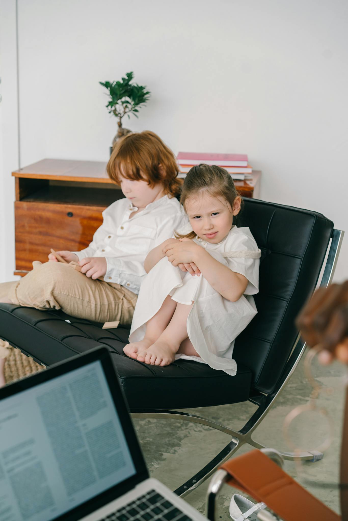 Two children in a cozy office for a counseling session, with a focus on mental health.